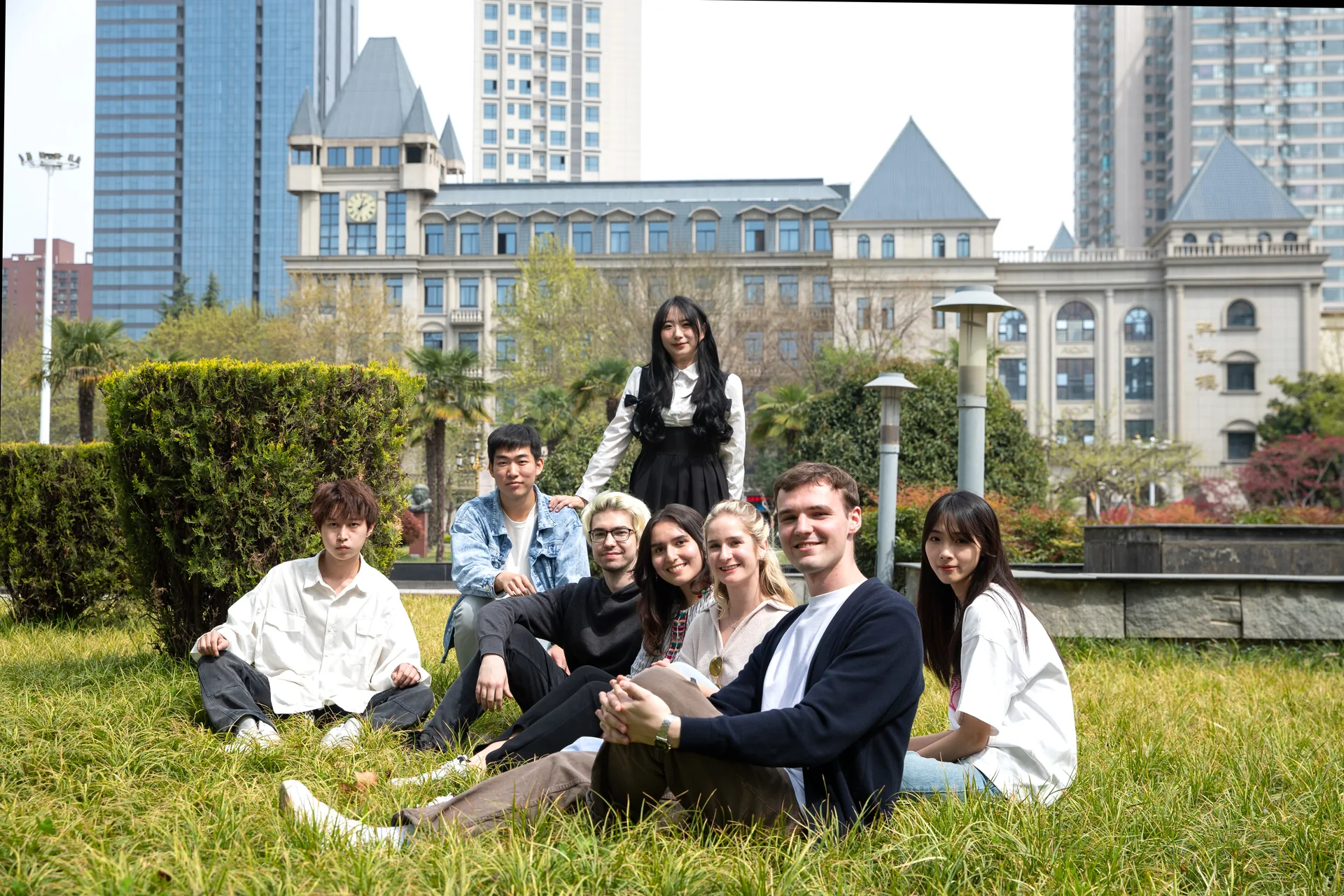A group of students sitting together on a campus lawn