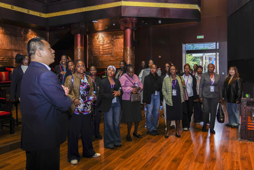 A visiting group listening to a talk in an exhibition hall