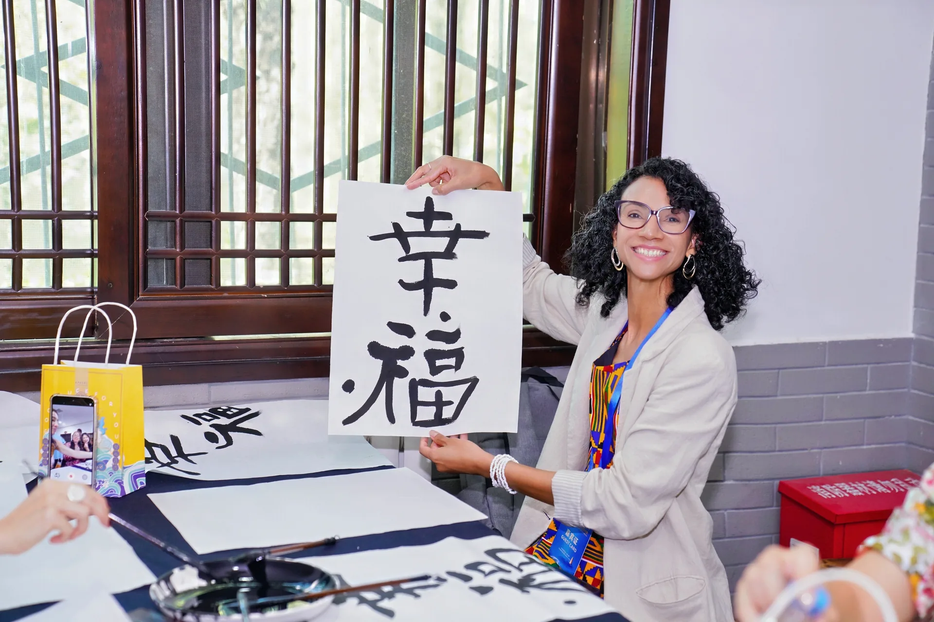 A student holding up a calligraphy scroll they have written