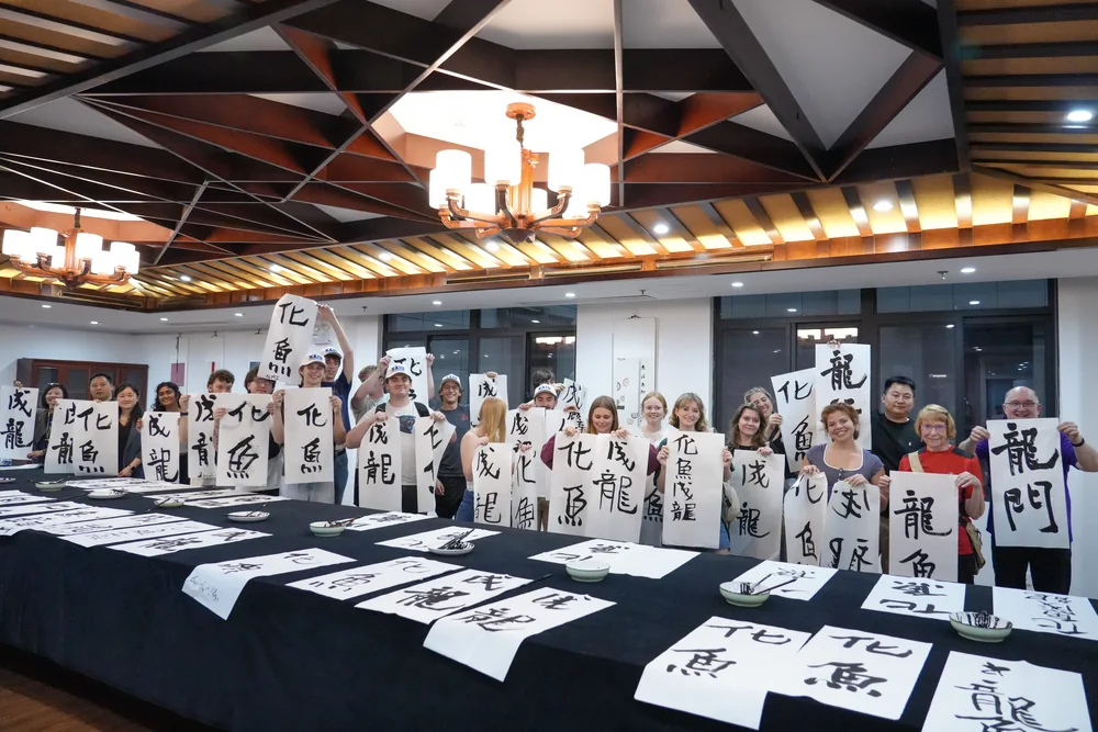 Students holding up the calligraphy they have just written