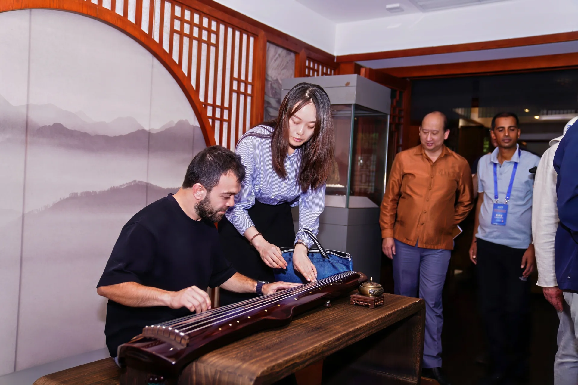 A teacher showing a student how to play the guqin