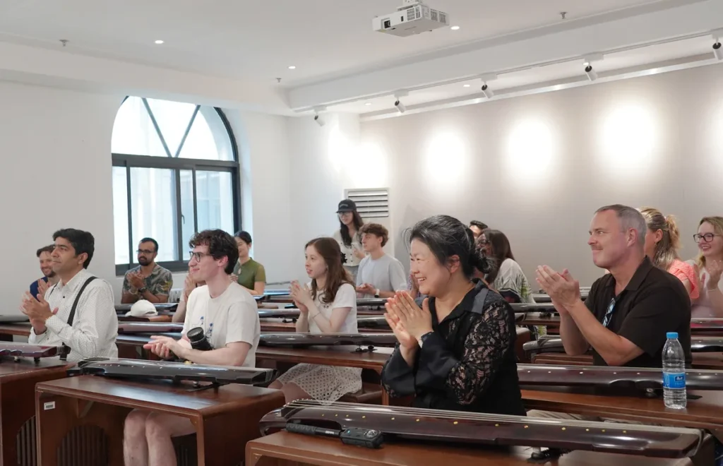 A class applauding from their seats at rows of guqin